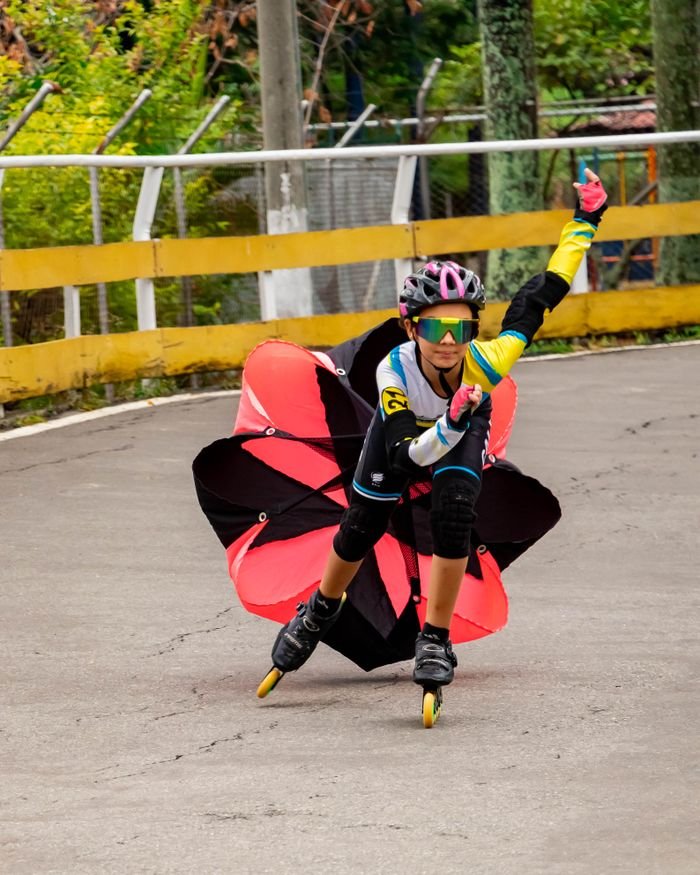 Dynamic shot of an inline skater performing a stunt using a parachute on a track in Cali, Colombia.