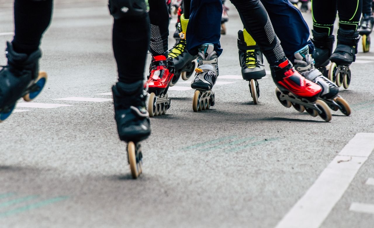A group of people rollerblading together on an urban street, showcasing dynamic movement and teamwork.